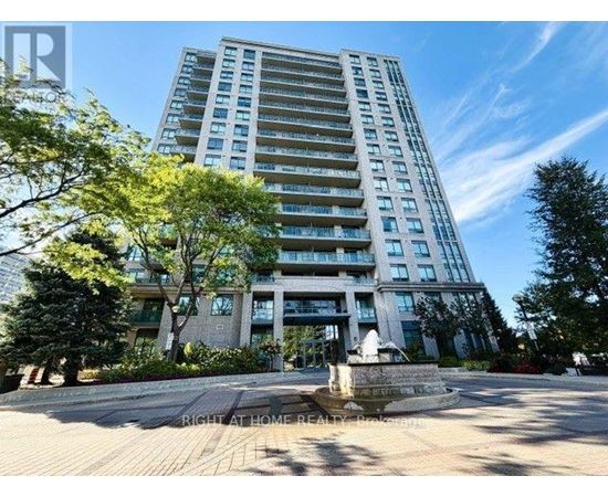 A tall residential building with a fountain in front.
