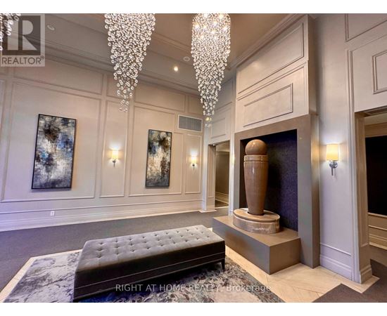 A living room with a chandelier, a fireplace, and a bench.
