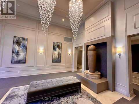 A living room with a chandelier, a fireplace, and a bench.