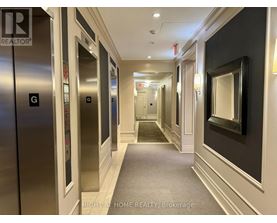 A hallway with elevators on the left and a mirror on the right.