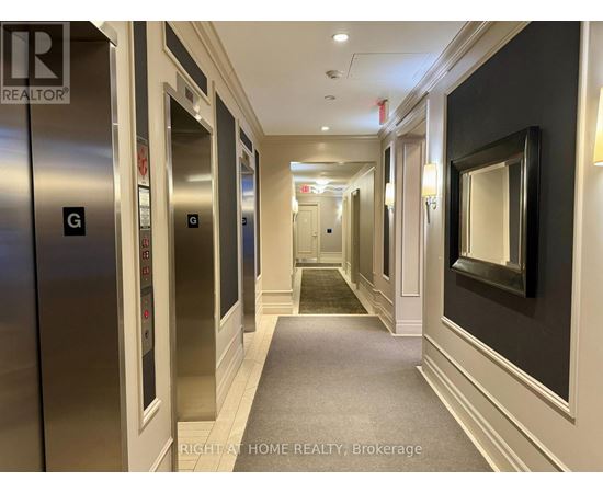 A hallway with elevators on the left and a mirror on the right.
