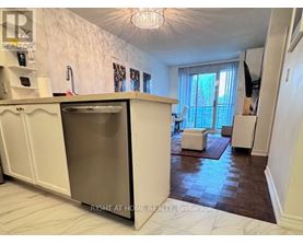 A kitchen with a refrigerator, sink, and a window with curtains.