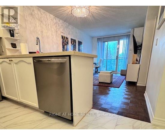 A kitchen with a refrigerator, sink, and a window with curtains.