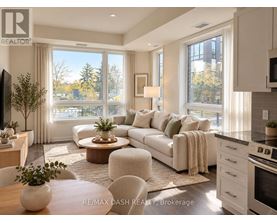 A well-lit, modern living room with a large window and a view of trees outside.