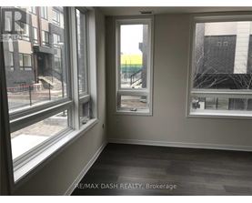 A room with a view of a street and buildings outside the window.