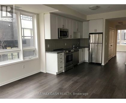 A kitchen with white cabinets and a black countertop.