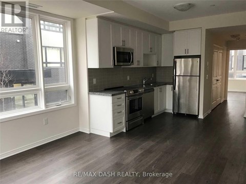 A kitchen with white cabinets and a black countertop.