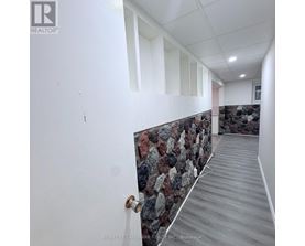 A hallway with a stone wall and wooden floor.
