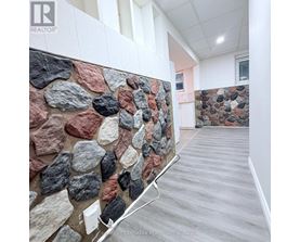 A stone wall in a room with a wooden floor.