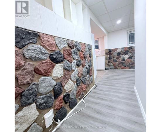 A stone wall in a room with a wooden floor.