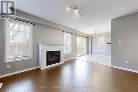 A spacious living room with a fireplace and hardwood floors.