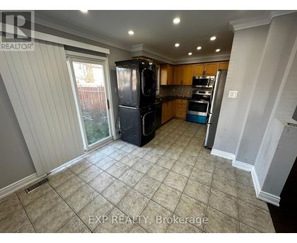 A kitchen with tile flooring and a refrigerator.