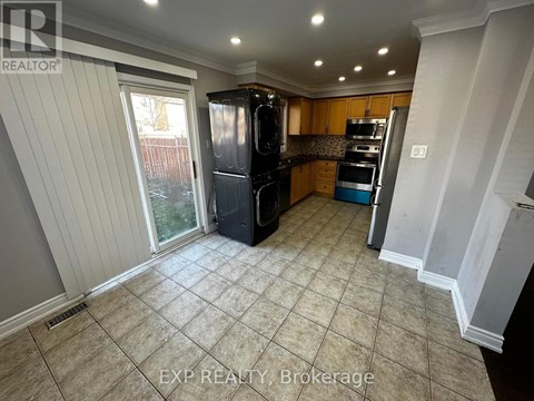 A kitchen with tile flooring and a refrigerator.