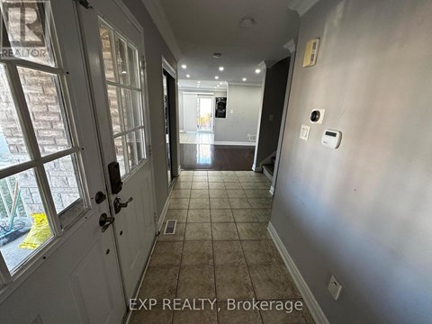 A hallway with a door on the left and a wall on the right.
