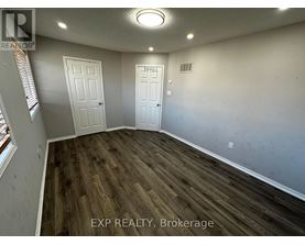 A room with wooden flooring and two white doors.
