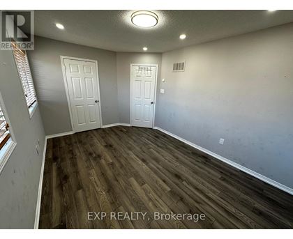 A room with wooden flooring and two white doors.