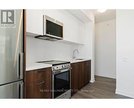A kitchen with a refrigerator, oven, microwave, and cabinets.