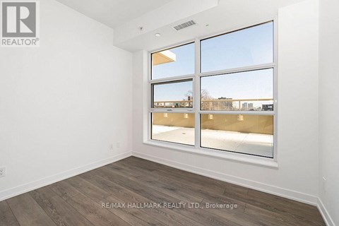 A room with a large window and wooden flooring.