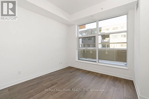 A room with a large window and wooden flooring.
