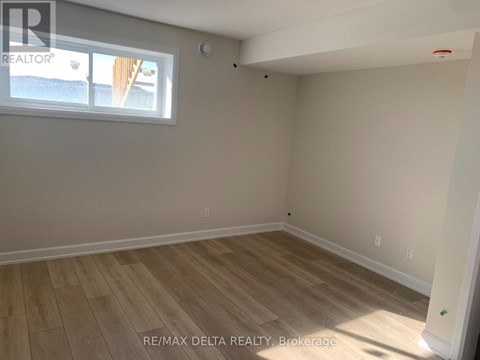 A room with a window and wooden flooring.