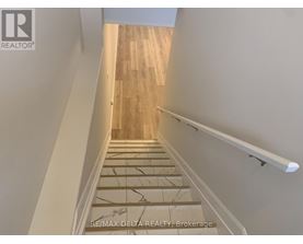 A staircase with wooden steps and a white handrail.
