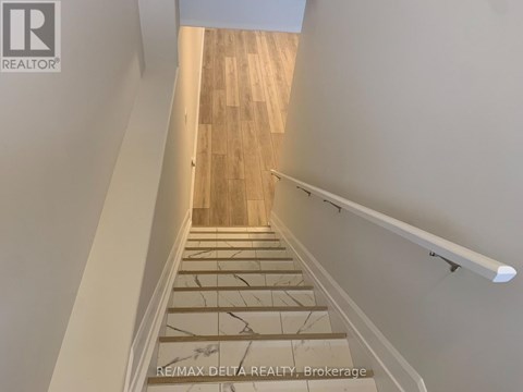 A staircase with wooden steps and a white handrail.
