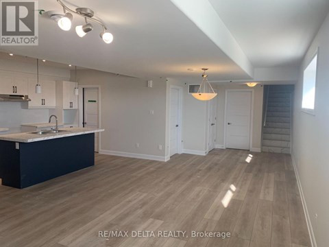 A spacious kitchen with white cabinets and a dark island.