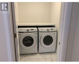 A pair of front loading washing machines in a laundry room.