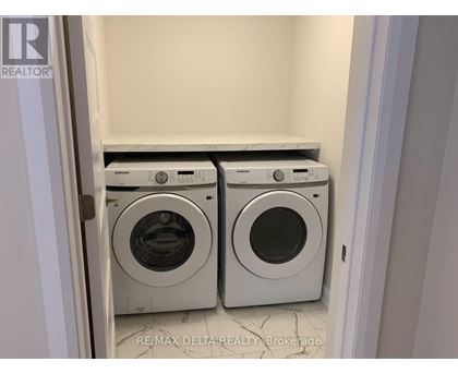 A pair of front loading washing machines in a laundry room.