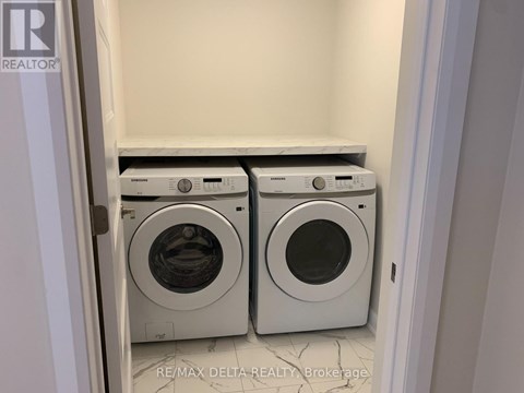 A pair of front loading washing machines in a laundry room.