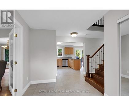 A spacious living room with a staircase leading to the upper floor.