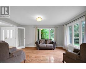 A living room with a couch, chairs, and a window.