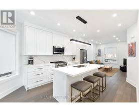 A modern kitchen with white cabinets and a central island.
