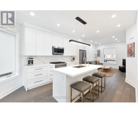A modern kitchen with white cabinets and a central island.