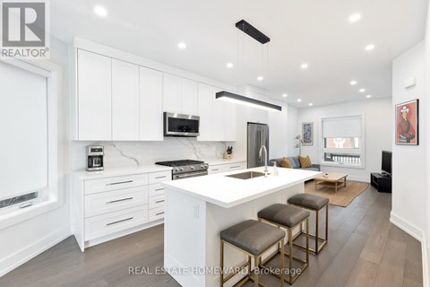 A modern kitchen with white cabinets and a central island.