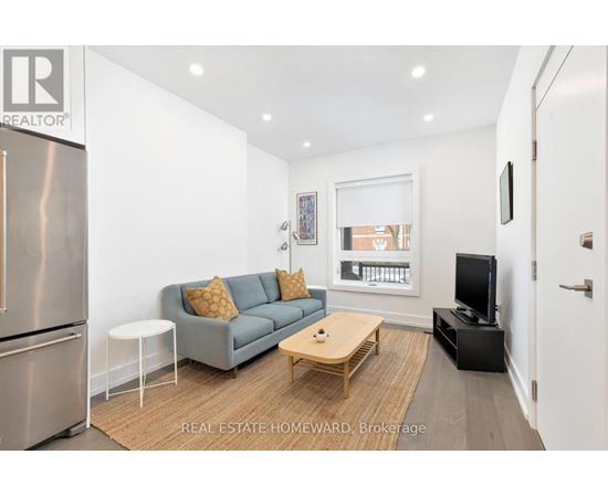 A modern living room with a grey couch and a wooden coffee table.