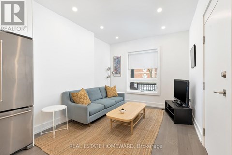 A modern living room with a grey couch and a wooden coffee table.