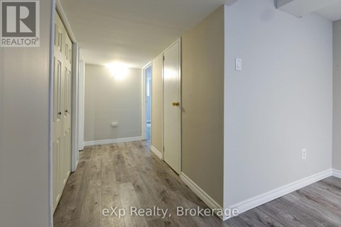 A hallway with wood flooring and white walls.