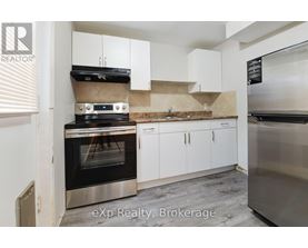 A kitchen with a stove top oven and white cabinets.