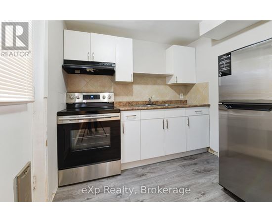 A kitchen with a stove top oven and white cabinets.