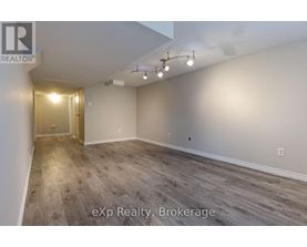 A room with wooden flooring and a doorway leading to another room.