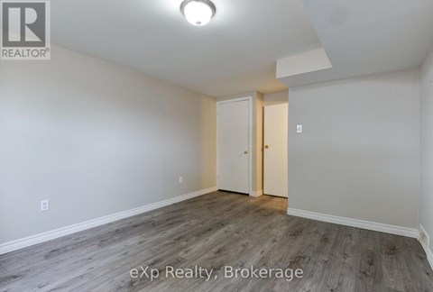 A room with a white door and a light on the ceiling.