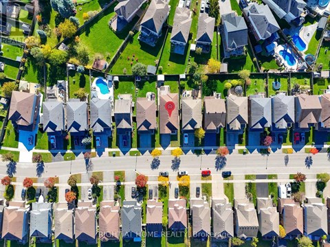 A bird's eye view of a neighborhood with houses and a pool.