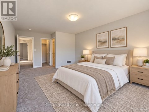 A bedroom with a large bed, two nightstands with lamps, and a carpeted floor.