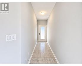A hallway with a door at the end and a light on the ceiling.