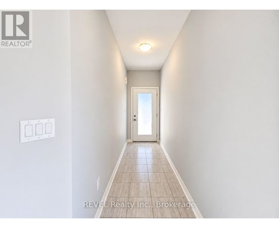 A hallway with a door at the end and a light on the ceiling.