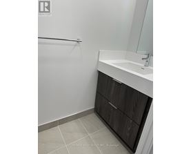A bathroom with a white sink and a wooden cabinet.