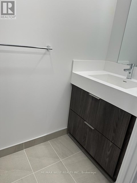 A bathroom with a white sink and a wooden cabinet.