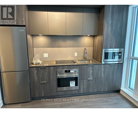 A modern kitchen with a stainless steel refrigerator and wooden cabinets.