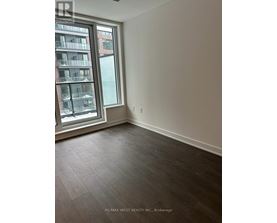 A room with a large window and a view of a building across the street.